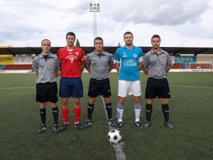 El trío arbitral del partido con los capitanes