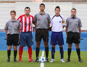 El trío arbitral con los capitanes del partido