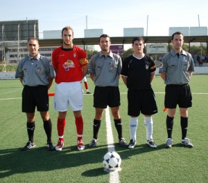 El trio arbitral con los capitanes del partido