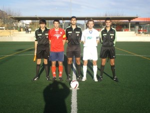 El trio arbitral con los capitanes del partido