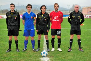 El trío arbitral con los capitanes del partido