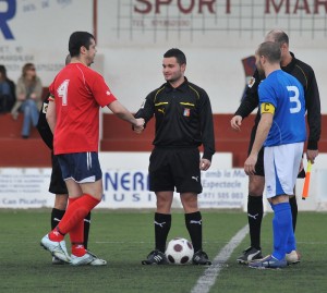 El colegiado con los capitanes del partido