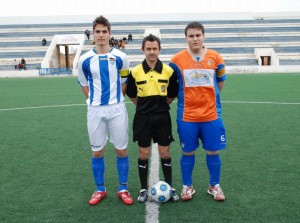 El colegiado con los capitanes del partido